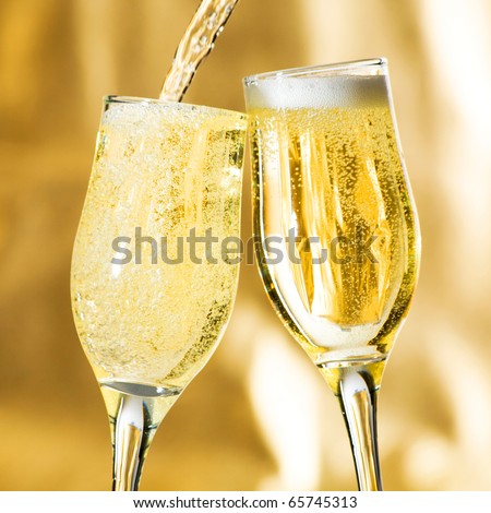 Pair of champagne flutes making a toast.