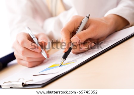 Close-up of business partners hands over papers discussing them
