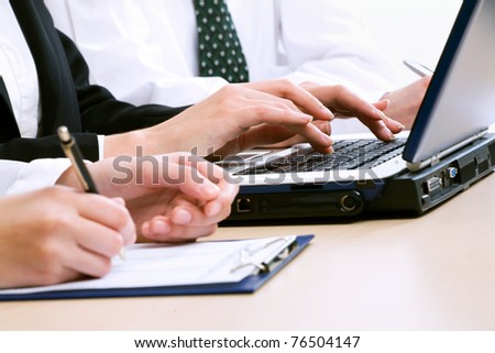 Close-up of people hands typing on computer keyboard in working environment