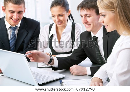Photo of business people looking at laptop monitor