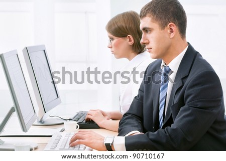 Young business people using computer at work desk
