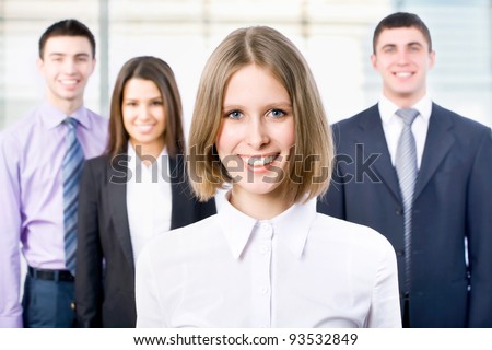 Portrait of female leader with cheerful team in background