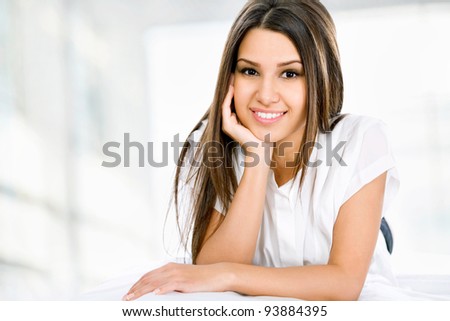 Pretty young woman using tablet pc while leaning on couch