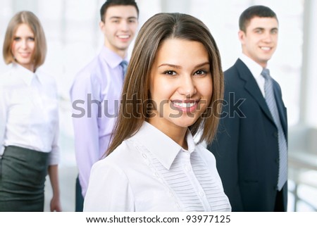 Portrait of female leader with cheerful team in background