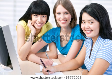 Three girl friends studying together in a classroom