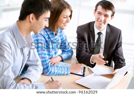 Manager talks to a young couple in the bank