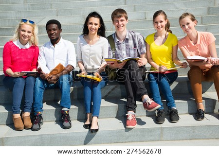 Group of university students studying reviewing homework