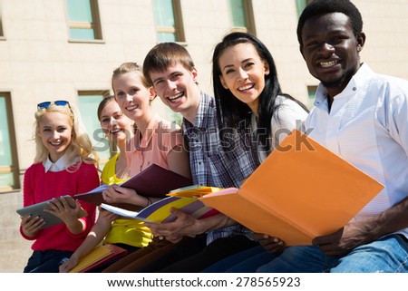 Group of university students studying reviewing homework