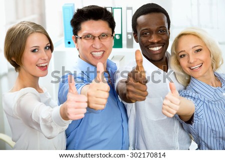 Business people with thumbs up and smilingin in office