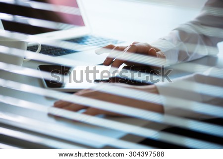 Close-up of hands of business man. View through blinds