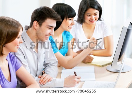 Young students studying together with computers