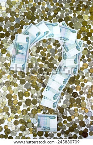 A question mark formed from currency notes on the background of the coins of Russian money.