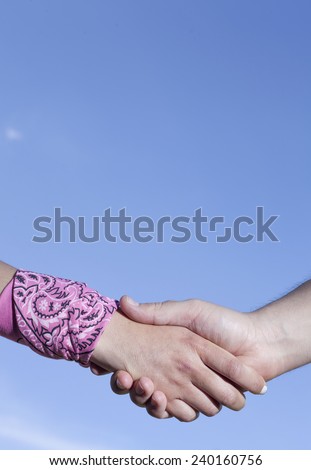 Hands clasped blue sky background