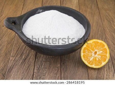 baking soda (sodium bicarbonate) in a wooden spoon and lemon