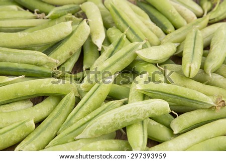 Fresh green peas on vintage scales on old wooden background. Selective focus. Healthy food concept. Retro style toned.