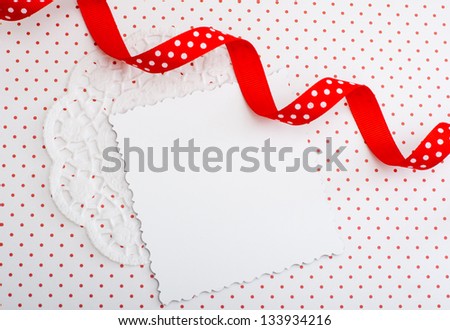White decorative card on a red and white background with a ribbon