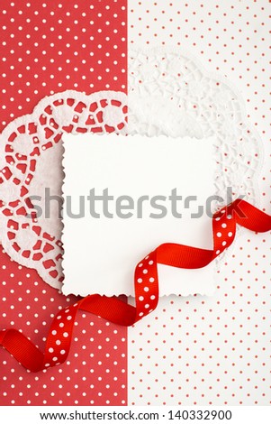 White decorative card on a red and white background with a ribbon