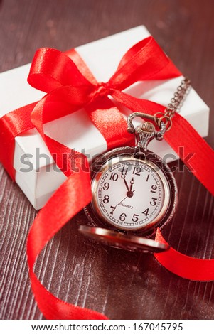 White box with a red bow and pocket watches