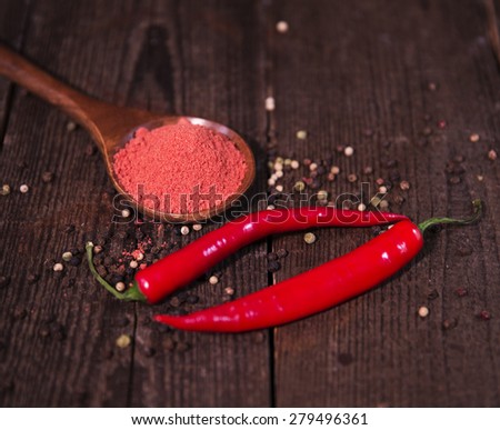 Spices powder and chili pepper on wooden background