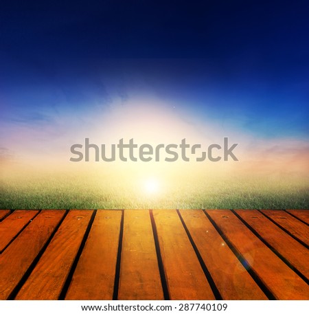 Fresh spring green grass with twilight sky sunlight and wood floor. Beauty natural background