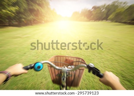 cyclist woman hands on handlebar bike on trail in summer park,vignette,flare