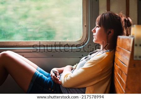 Girl on train. Listen to music. Travel
