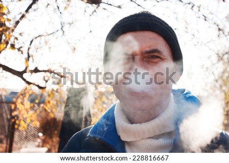 Steam from mouth. Portrait of man in warm clothing. Cold weather