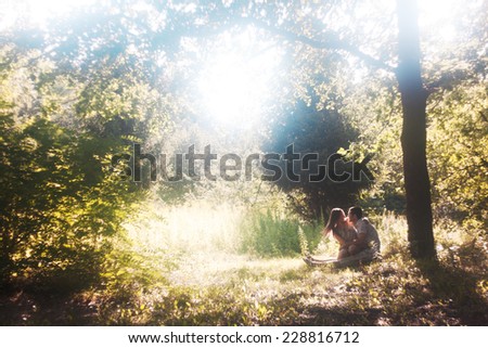 Lovers under tree. Romantic relationship, first love. Forest landscape with large tree. Backlight
