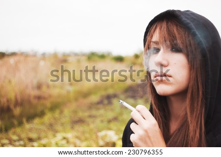 Smoking girl with cigarette. Portrait of beautiful brunette. Bad habit, addiction, problems with health. Smoke from mouth