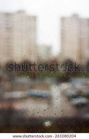 Drops of rain. View on city street through window in rain