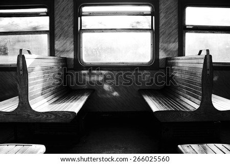 Couple of benches in train. Travel in transport. Backlight. Black and white photo