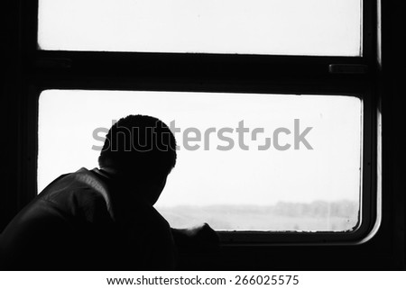 Passenger in train. Journey by rail. Landscape in window. Loneliness. Black and white photo