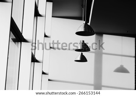 Interior of cafe. Fragment of interior of cafe with lamps and their shadow. Black and white photo