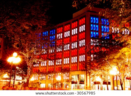 office building with the american flag lighting in the evening