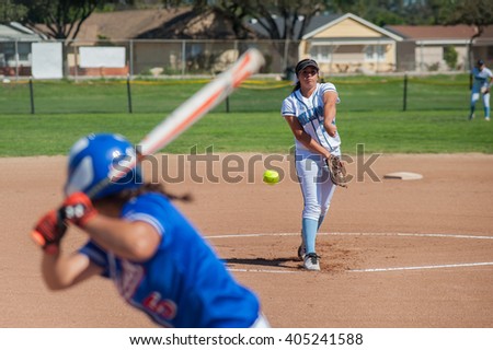Close up of softball pitcher throwing the curve ball to the batter.