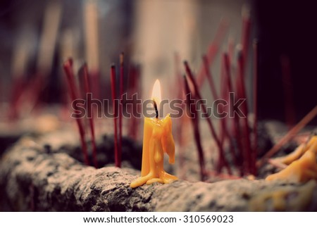 The lighted candle on joss stick pot, selected focus on the candle