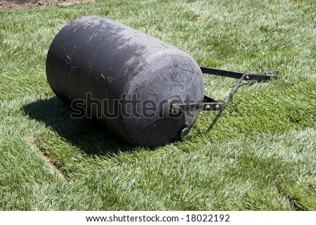 Lawn roller is in the grass