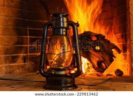 Oil lamp near the fireplace on a background of fire