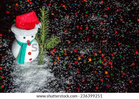 Christmas decoration - Snow man with fir branch on black background with many colored lights