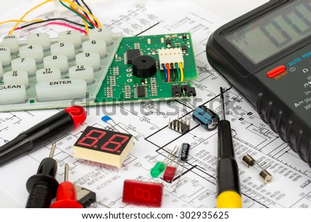 Alarm workbench electronics repair, electronic diagram, multimeter, electronic components, electronic board, screwdrivers, transistors, integrated circuits, capacitors, LED