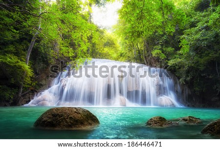 Tropical waterfall in Thailand, nature photography. Fresh water mountain river in wild green jungle forest. Scenic and peaceful Asia nature background of beautiful blue water pool and creek cascade
