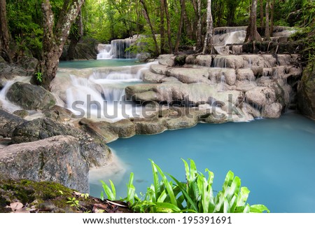 Thailand outdoor photography of waterfall in rain jungle forest. Trees, foliage and clear water of mountain river