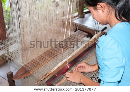 LUANG PRABANG, LAOS - 8 DEC, 2013: Unidentified female worker in silk production factory. Traditional way of making textile is very popular tourist attraction.