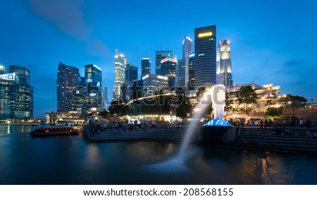 SINGAPORE - 1 JAN, 2014: Marina Bay central business district in Singapore. Late evening panorama of popular tourist area in downtown of city. Merlion statue in the front is the symbol of Singapore