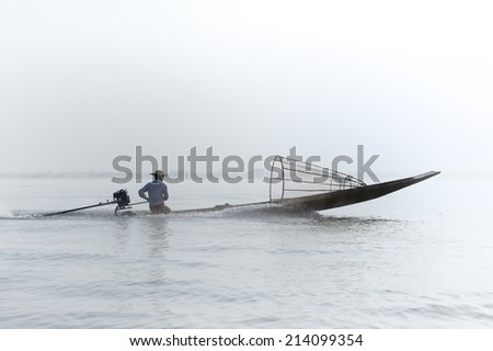 Myanmar, Shan state, Inle lake Intha fisherman on boat at early morning with fog and mist background
