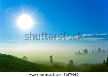 Foggy nature background. Blue sky and green landscape