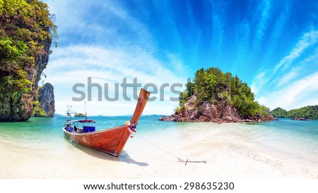 Amazing nature and exotic travel destination in Thailand. Thai tourist boat on white sand beach of small tropical island