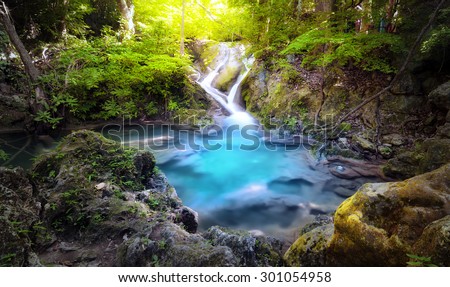Majestic nature background of mountain river stream and small blue water lake in wild tropical forest