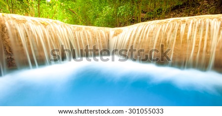 Fresh water river flows and falls from waterfall cascade. Smooth and silky stream nature background