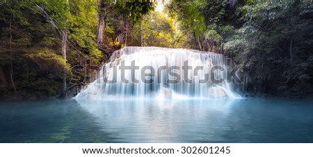 Cool fresh water pond in forest with smooth and silky waterfall cascades. Nature background panorama